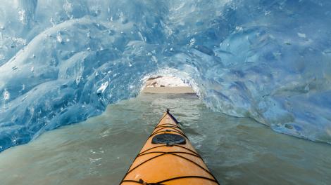 Surreal view surrounding a kayaker navigating through a cave at Mendenhall Glacier Lake