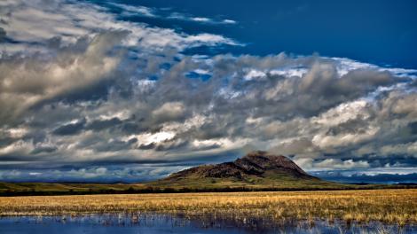 Bear Butte rising to meet the clouds