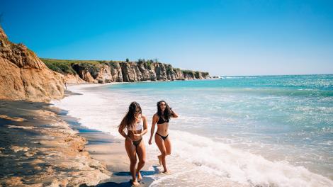 ビエケス島の黒砂のビーチをそぞろ歩く人