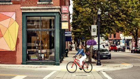 Ciclista observando las vistas en el pueblo pequeño de Biddeford, Maine Ciclista observando las vistas en el pueblo pequeño de Biddeford, Maine