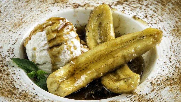 Bananas Foster, un postre flambeado de bananas con un toque de ron, es una de las recetas icónicas de Luisiana con las que te encontrarás en el Creole Crescent Trail.
