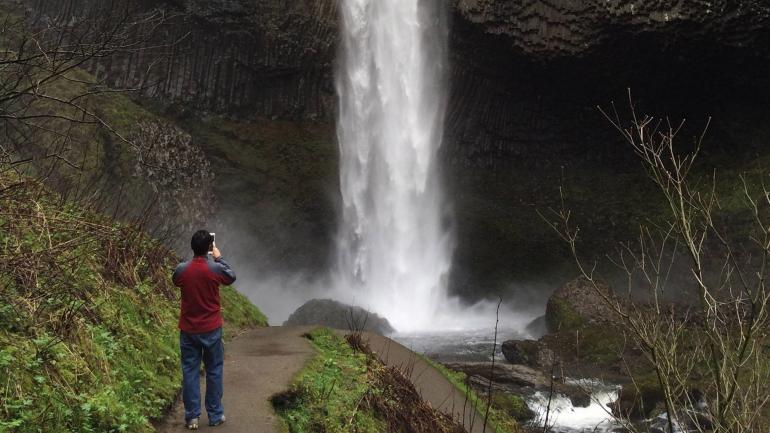 A hiker photographing Latourell Falls