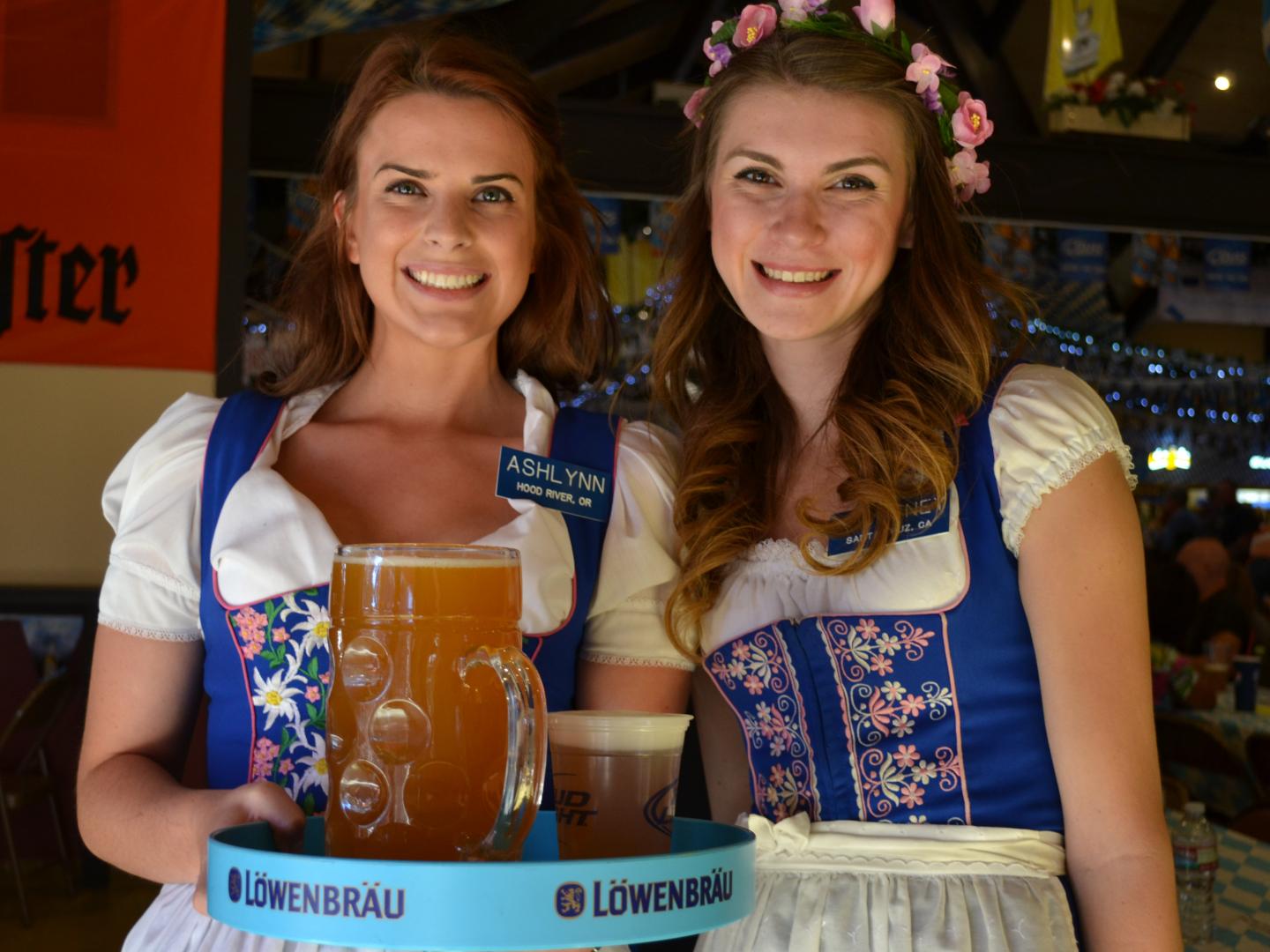 Femmes prenant la pose en tenue traditionnelle, avec un plateau de bières allemandes, lors du Big Bear Lake Oktoberfest