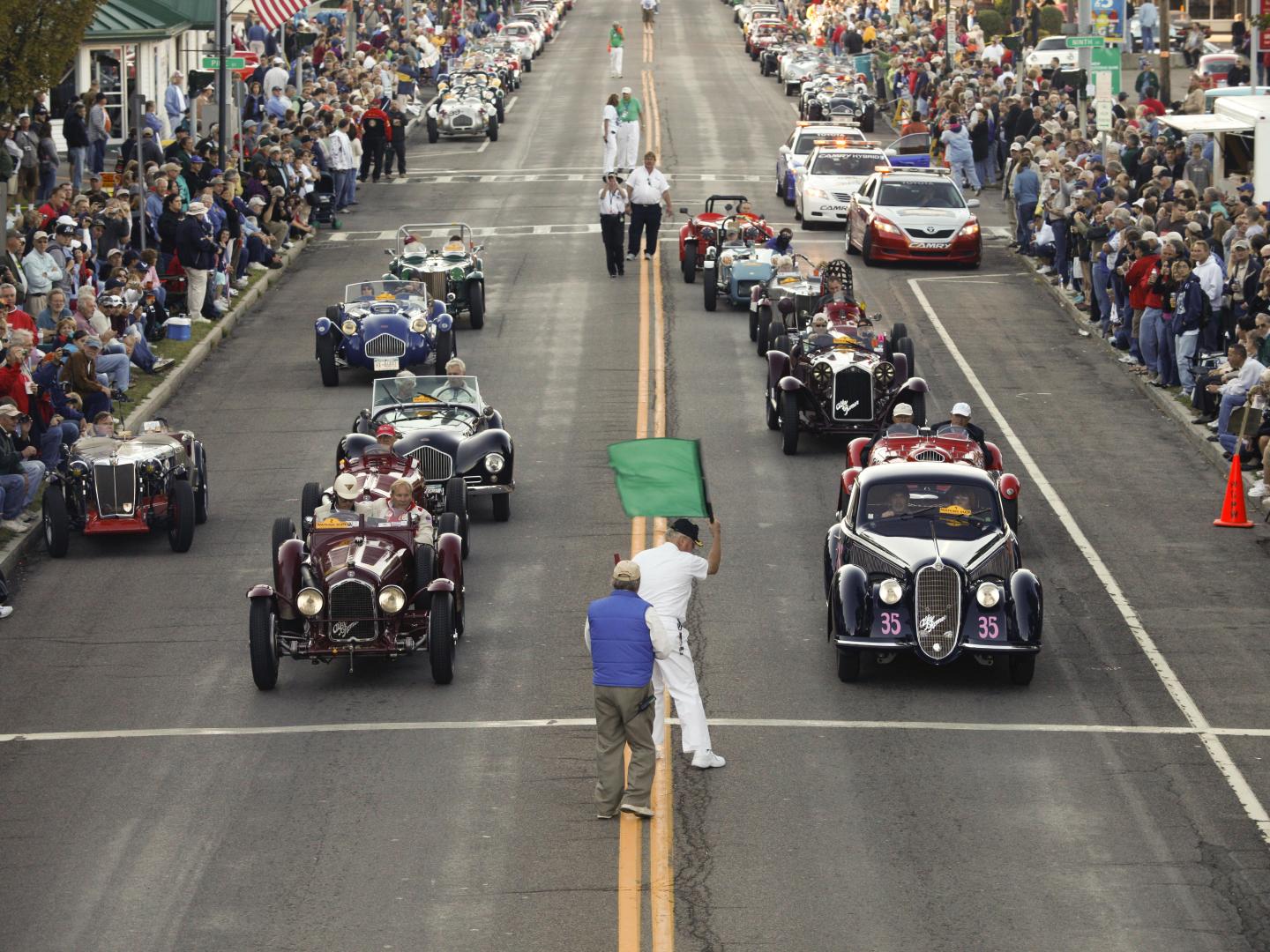 Vintage cars parade through the streets of Watkins Glen, New York, at the annual Watkins Glen Grand Prix Festival