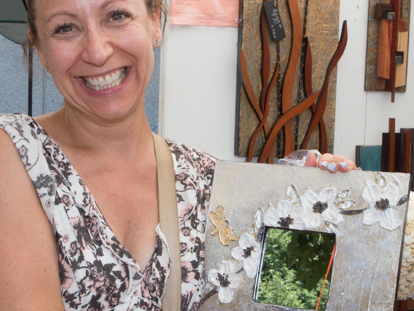 An artist shows off a painting at Corn Hill Summer Arts Festival in Rochester, New York