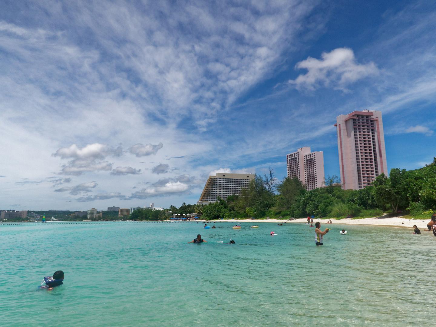 Beachgoers playing in the surf at Ypao Beach in Guam
