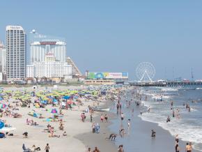 享受沙滩和冲浪的海滩游客 享受沙滩和冲浪的海滩游客