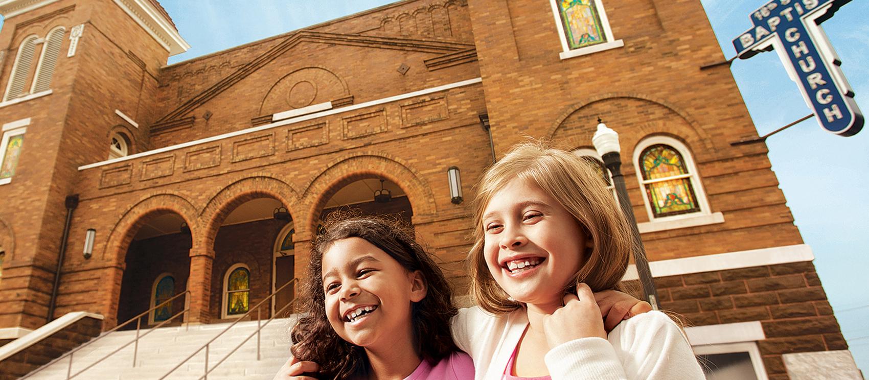 Children smiling in front of 16th Street Baptist Church in Birmingham